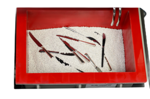 Des couteaux en cours de traitement par la tribofinition dans le vibrateur linéaire série TU.