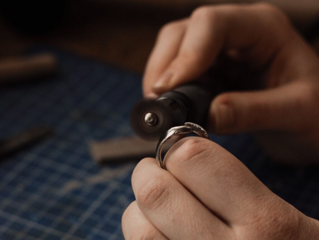 un bijoutier qui poli une bague