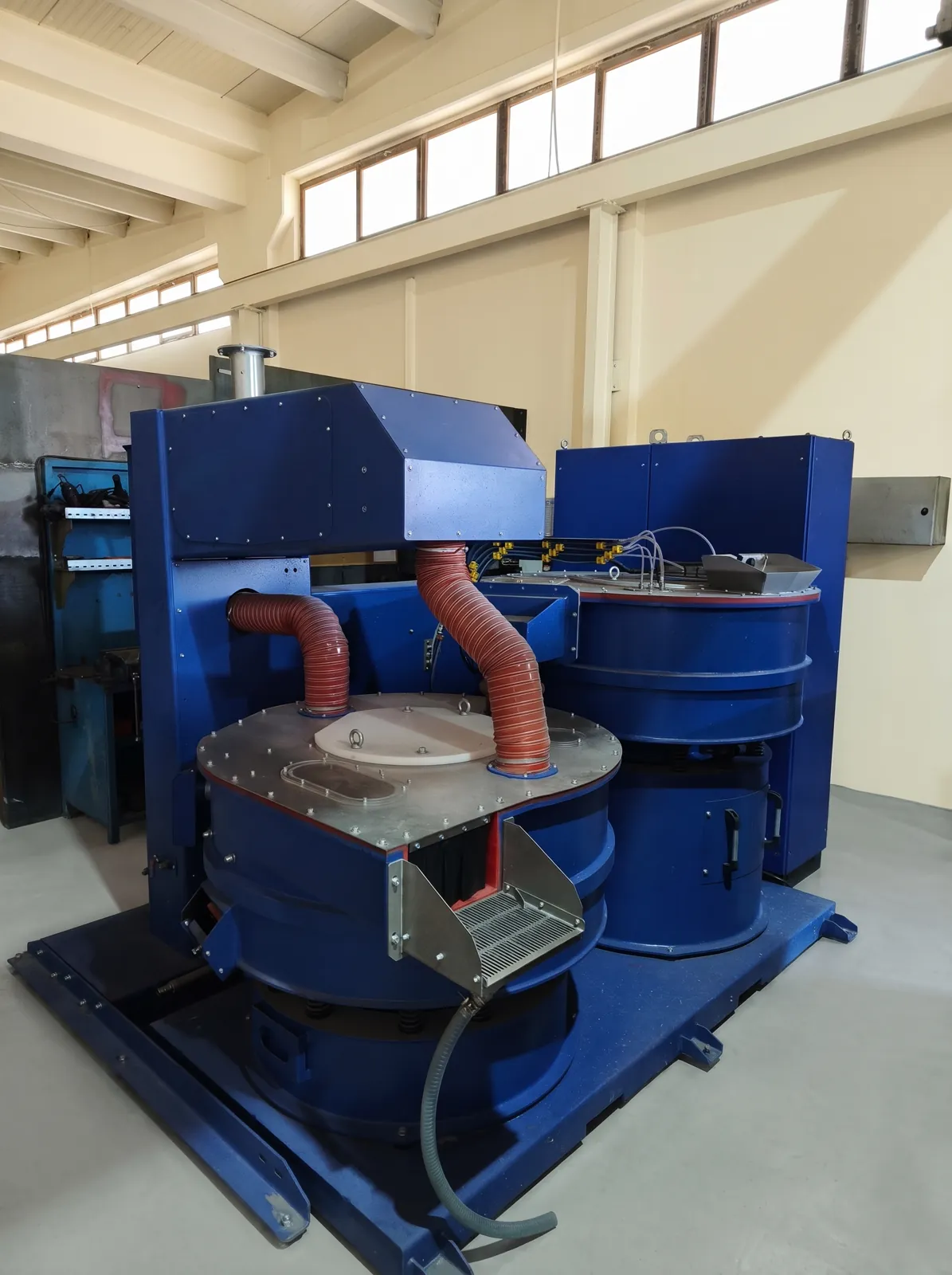 Vibrateur circulaire équipé d'un capot d'aspiration et d'une goulotte inox de déchargement.